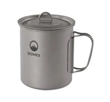 A lightweight Domex Titanium Pot with a lid and foldable handle, perfect for camp cookware, features a mountain logo and the Domex brand on its side. Shown against a white background.
