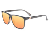 A pair of Knockaround Fast Lane Sport Sunglasses by Knockaround with orange-tinted polarized lenses and a "K" logo on the left temple, offering top-notch UV protection.