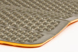 Close-up of a gray, textured closed-cell foam mat with a yellow base, likely used for cushioning or insulation during ultralight backpacking. The mat shown is the Exped Flexmat by Exped.