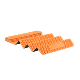 Four stacked Exped Flexmat with a ribbed texture and a branded Exped label on the topmost piece against a white background, reminiscent of gear used in ultralight backpacking.