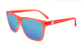 An orange frame Knockaround Fast Lane Sport Sunglasses with blue-tinted, polarized lenses and a small white "K" logo on the temple, offering superior UV protection.