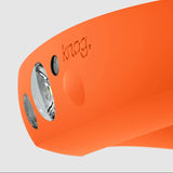 Close-up of the Knog Quokka 150 Headlamp in orange with a glossy finish, showcasing a round lens and a small button on its side. This USB rechargeable accessory ensures you're always ready for the ride ahead.