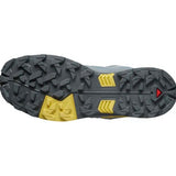 The image showcases the textured sole of the Salomon X Ultra 5 Men's Hiking Shoe in gray and yellow, with triangular and geometric grip patterns enhanced by Contagrip technology for superior traction.