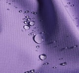 Water droplets bead on the textured purple Mammut Alto Light HS Women's Jacket, showcasing its waterproof design and lightweight construction—perfect for outdoor adventure.
