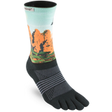 The Injinji Women's TRAIL Midweight Crew by Injinji is a black trail running toe sock with a mountain landscape design and gray stripes, designed to prevent blisters during outdoor adventures.
