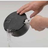 A person pours water from a Soto Navigator Camping Cookware Set, holding the lid with one hand and gripping the handle with the other—demonstrating the set's versatile design for outdoor cooking by Soto.