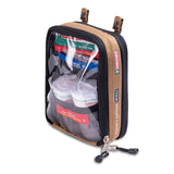 The Survival Travel First Aid Kit by Survival First Aid is a clear pouch featuring essential supplies, such as SMART Bandage rolls and instruction pamphlets, secured with a brown and black zipper.