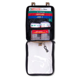 Open the Survival Travel First Aid Kit by Survival First Aid for bites. It includes SMART Bandages, instructions, a whistle, and an emergency blanket. Items are neatly stored in a zippered case with a transparent pocket for easy access.