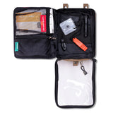 Introducing the Survival First Aid's Survival Travel First Aid Kit, featuring a SMART bandage, whistle, flashlight, and plastic sheets. Efficiently organized in pockets and a clear compartment for ultimate convenience.
