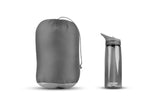 A gray Sea To Summit Treeline ATLI Sleeping Bag with a drawstring closure is placed beside a gray CamelBak water bottle with a spout lid.