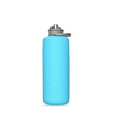 The HydraPak Hydrapak Flux Bottle 1L is a light blue reusable bottle with a textured surface, drop-shaped logo, and gray flip-top lid, made from durable dual-layer TPU for flexibility and strength against a white background.