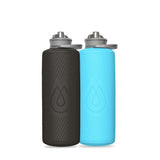 Two Hydrapak Flux Bottle 1.5L, one black and one blue, with lightweight, compact designs, textured grips, and closed spouts are side by side on a plain white background.