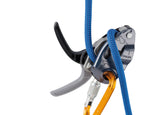 A close-up of a blue climbing rope threaded through a Petzl Gri Gri assisted braking belay device, attached to an orange locking carabiner.