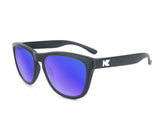 Knockaround Kids Premium Sunglasses by Knockaround feature black frames, blue mirrored polarized lenses with UV400 protection, and a white "K" logo on the temples. Displayed on a plain white background.