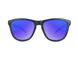 Knockaround Kids Premium Sunglasses by Knockaround, shown from the front on a white background, feature black frames with blue-purple mirrored polarized lenses and UV400 protection.