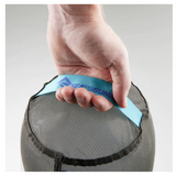 A person holding a Sea to Summit Mesh Stuff Sack, an ultra-lightweight black mesh bag with a blue strap, for gear organization.