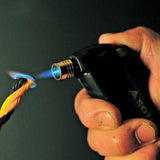 A hand uses the Soto Pocket Torch, a wind-resistant burner by Soto, to melt the end of a yellow and black synthetic rope.