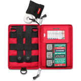 Open the Survival Handy First Aid Kit by Survival First Aid, a red portable kit featuring organized compartments with labels for trauma, hygiene, information, and utilities. It includes a QR code, a color coding chart, an emergency blanket, and a small pouch containing tape.