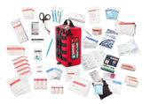 A comprehensive Survival Workplace First Aid Kit by Survival First Aid featuring various medical supplies, including bandages, scissors, antiseptic wipes, a CPR chart, gloves, gauze, a cold pack, medical tape—all packed in a water-resistant red survival first aid bag with the versatile MOLLE system for easy attachment.