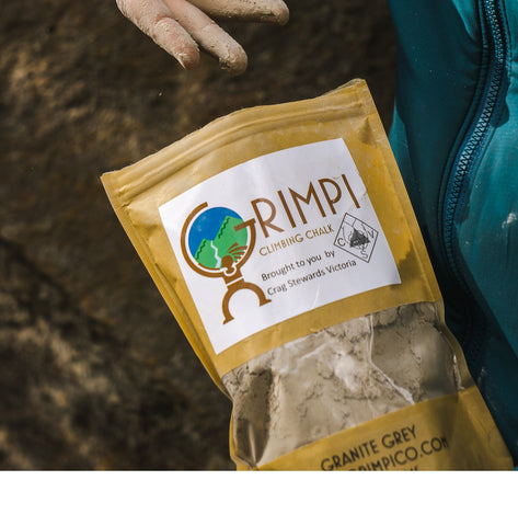 Person holding a bag of Absolute Outdoors Grimpi Coloured Loose Chalk 150g.