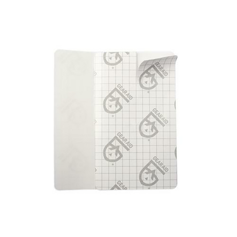 A partially peeled Gear Aid Tenacious Tape Flex Patch (76 x 127mm), rectangular with a grid and Gear Aid logo pattern, is shown on a white background.
