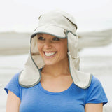 A woman wearing a Sunday Afternoons Sun Guide Cap on the beach, providing UPF50+ protection.