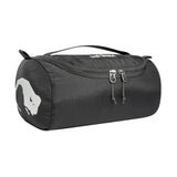 A black cylindrical zippered bag called the Tatonka Care Barrel Wash Bag by Tatonka features a white bear silhouette on one side and a handle at the top.