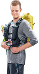 A person using a vest-style carry system with two water bottles, holding a smartphone, and carrying the vibrant yellow Deuter Vertrail 16 alpine pack by Deuter.