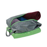 The Tatonka Double Stuff Bag by Tatonka, featuring durable green and grey T-Rip fabric, is partially unzipped to reveal several rolled-up towels or blankets inside.