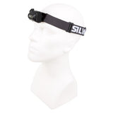 A white mannequin head wears a black, lightweight Silva Scout 2RC Headlamp with an adjustable strap featuring the letters "STW" and a rechargeable battery.