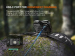 The Fenix Lighting HL12R V2.0 SST20 white & 2835 Red LED headlamp, offering 500 lumens, charges via USB-C on a mossy surface. Text highlights fast, convenient USB-C charging and the battery level indicator is shown.