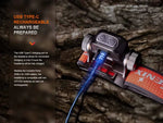 The Fenix Lighting HM65R-T V2.0 headlamp with Luminus SST40 & OSRAM LEDs is shown charging via USB Type-C, offering hands-free lighting and alternative battery compatibility—perfect for trail running needs.