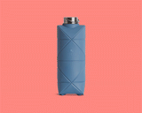 The DiFold Origami Bottle by Difold is a blue, collapsible water bottle featuring a geometric pattern, made from plant-based polymer, presented in both expanded and compressed forms on a solid pink background.
