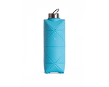 The DiFold Origami Bottle by Difold is a blue, rectangular bottle with geometric patterns, made from plant-based polymer. It features a metal screw-on lid and a small carrying loop, standing upright on a white background.