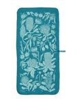 The Mont Flora Microfibre Travel Towel by Mont is a teal rectangular towel adorned with light blue botanical illustrations, made from recycled polyester. This quick-drying towel includes a loop for convenient hanging.