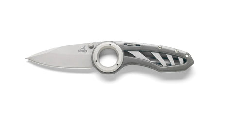 A Gerber Remix Folding Knife with a circular finger hole in the handle and a partially serrated, corrosion-resistant blade on a white background.