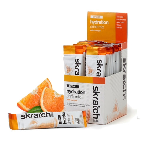 Skratch Labs Sport Hydration Drink Mix Single Serving 20-Pack in orange flavor—ideal for electrolyte replacement during workouts and pictured with fresh orange wedges.