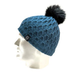 A mannequin head showcases the Domex Beanie by Domex—a blue knit beanie featuring a black faux fur pom-pom and a small black logo tag—ideal for anyone looking for warm, stylish winter hats.