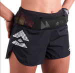 A person is sporting the T8 Women's Sherpa Shorts, which are black with a geometric logo and include a stretch waistband designed to hold small items securely. These lightweight shorts, crafted by T8, provide bounce-free comfort for active days.