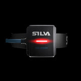 A Silva Trail Runner Free H headlamp by Silva, featuring a red safety light and designed for running, positioned in the center against a black background.