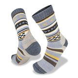 A pair of Wilderness Wear Merino Fusion Max Socks made with Climayarn technology, featuring various patterns including stripes and triangles in shades of gray, white, yellow, and brown. These socks also boast a reinforced heel and toe for added durability.