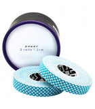 Two rolls of Crux Power Climbing Finger Tape in a light blue mesh pattern are partially unrolled and positioned in front of a cylindrical container labeled "power, 2 rolls, 1.2 cm." This durable adhesive from Crux Climbing provides excellent finger protection for the most demanding activities.