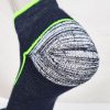 Close-up of a Wilderness Wear 10K Merino Sock in navy blue, featuring a visible hole in the heel that reveals its white and black patterned interior. This breathable performance sock from Wilderness Wear is crafted from merino wool for ultimate comfort and durability.