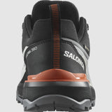 A close-up rear view of a black and orange Salomon Men's X Ultra 360 GTX shoe, highlighting its durable Contagrip sole.