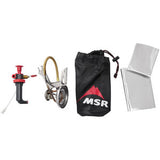 Camping stove set including a red fuel pump, MSR - Whisperlight International Multi Fuel Stove, black storage bag, and two silver heat reflectors isolated on a white background.