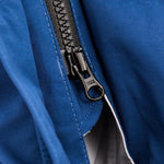 Close-up of a black zipper on a blue bushwalking rain jacket. The zipper is partially open, revealing a bit of the white inner lining of the waterproof breathable Hydronaute fabric. This is the Mont Men's Austral JKT by Mont.