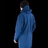 Person wearing a Mont Men's Austral JKT by Mont and a black beanie, facing away from the camera against a black background.