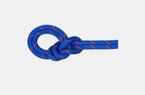 A blue Mammut 9.5 Crag Dry Rope with red and white patterns is tied in a double overhand knot against a plain white background.