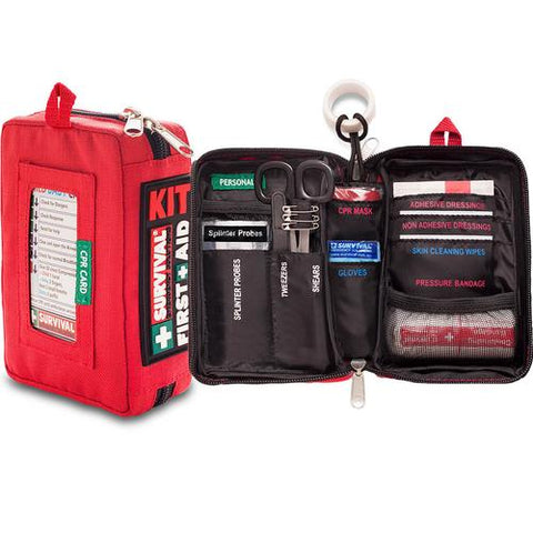 A Survival Compact First Aid Kit by Survival First Aid is shown open, revealing various medical supplies including adhesive dressings, gloves, a CPR mask, scissors, tweezers, spirit probes, and a pressure bandage. This portable trauma solution ensures you're equipped for any emergency.