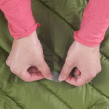 A person is using Gear Aid Tenacious Tape Repair Patches from the brand Gear Aid to fix a sleeping bag.